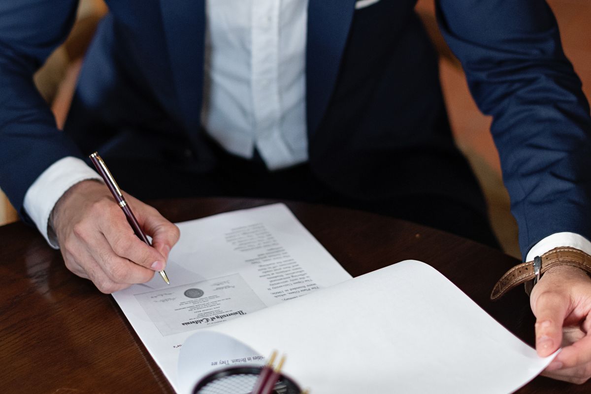 Notary signing paperwork at a client's table